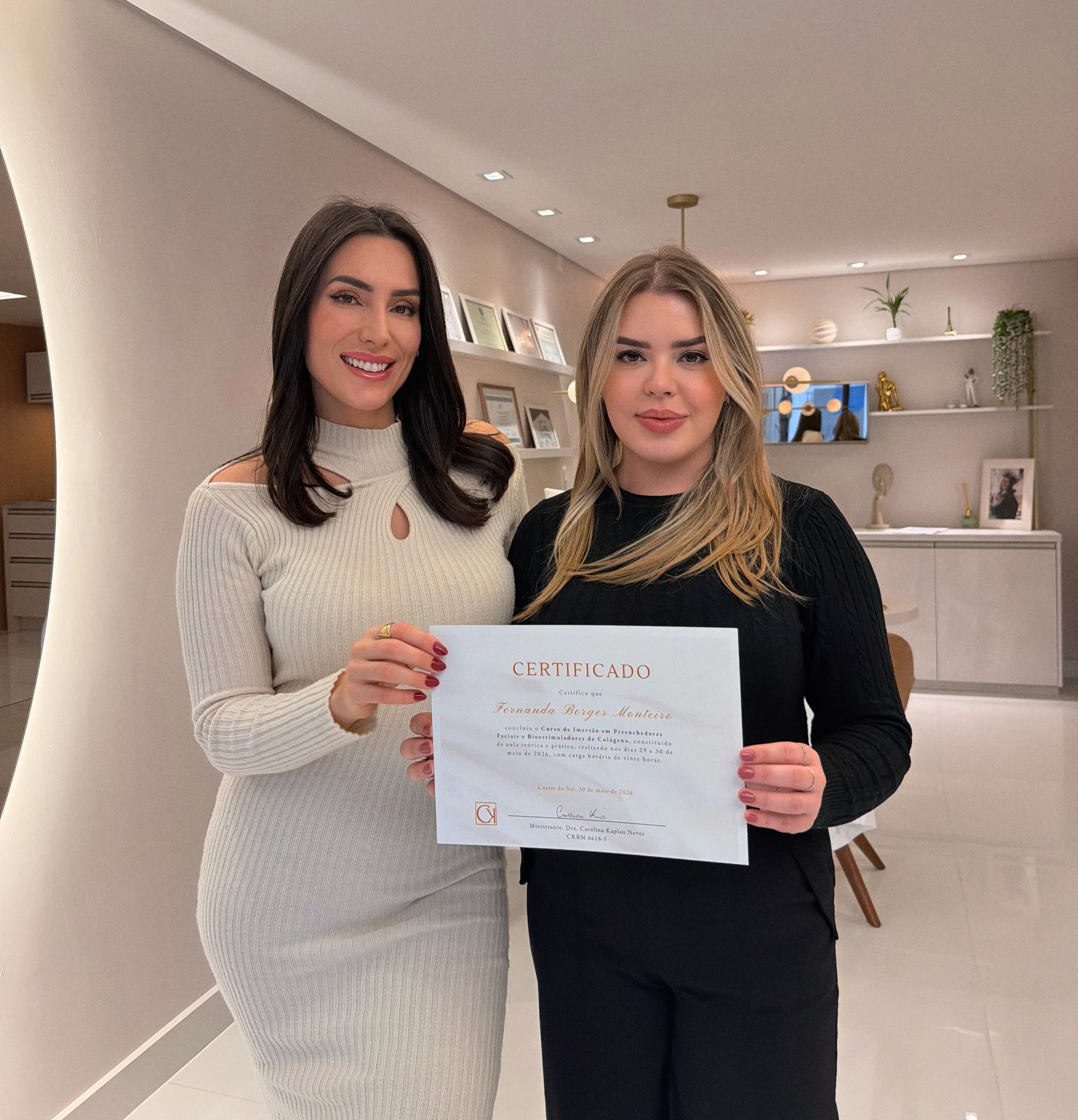 Dra. Carolina Kaplan com outra profissional e um certificado em contexto de curso
